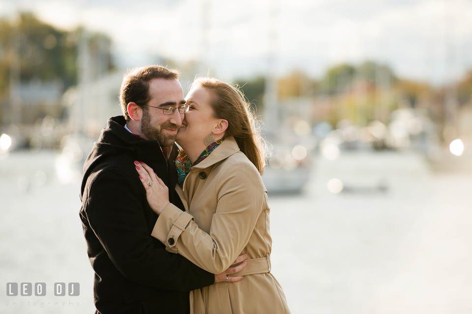 Engaged girl laughing and kissing her fiancé by the boat dock. Annapolis Eastern Shore Maryland pre-wedding engagement photo session at downtown, by wedding photographers of Leo Dj Photography. http://leodjphoto.com