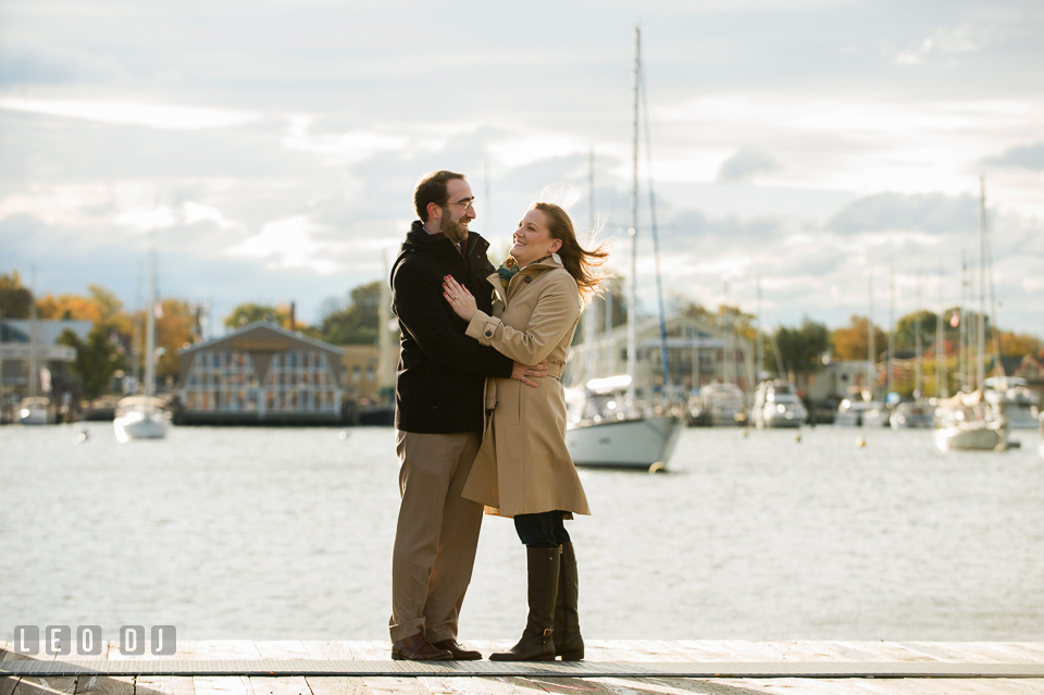 Engaged couple smiling and hugging on the pier. Annapolis Eastern Shore Maryland pre-wedding engagement photo session at downtown, by wedding photographers of Leo Dj Photography. http://leodjphoto.com