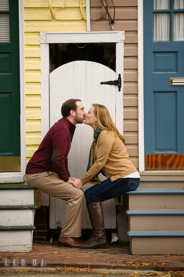 Engaged girl and her fiance sitting on colorful stairs and kissing. Annapolis Eastern Shore Maryland pre-wedding engagement photo session at downtown, by wedding photographers of Leo Dj Photography. http://leodjphoto.com