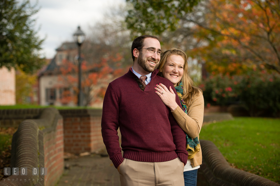 Engaged woman cuddled her fiance, smiling together by the State House. Annapolis Eastern Shore Maryland pre-wedding engagement photo session at downtown, by wedding photographers of Leo Dj Photography. http://leodjphoto.com