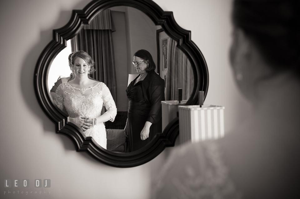 Bride looking at mirror while having her wedding gown put on. The Tidewater Inn wedding, Easton, Eastern Shore, Maryland, by wedding photographers of Leo Dj Photography. http://leodjphoto.com