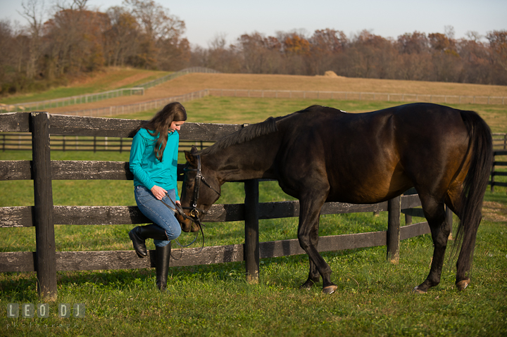 Girl and a horse by a fence on the field. Montgomery County high school senior portrait session at Wyndham Oaks, Boyds, Maryland horse stables by photographer Leo Dj Photography. http://leodjphoto.com