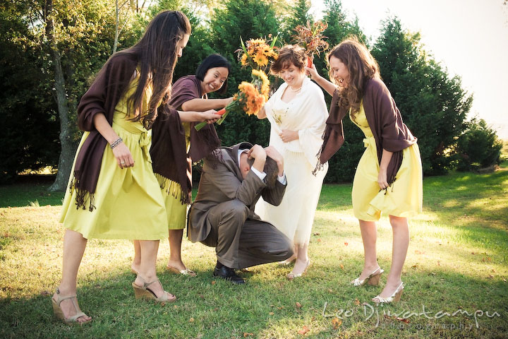 Bride, maid of honor, and bridesmaids beating groom with their bouquets. Rock Hall, Chestertown, Kingstown, and Georgetown Maryland wedding photographer, Leo Dj Photography