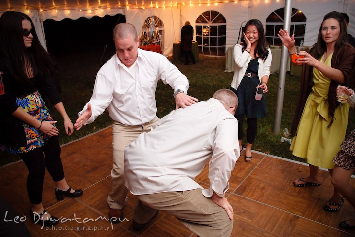 A guy slapping another guy's behind while dancing. Rock Hall, Chestertown, Kingstown, and Georgetown Maryland wedding photographer, Leo Dj Photography