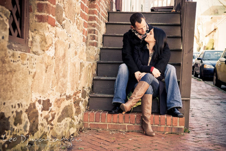 engaged couple sitting on stairs, cuddling. Urban City Pre-wedding Engagement Photographer Annapolis MD