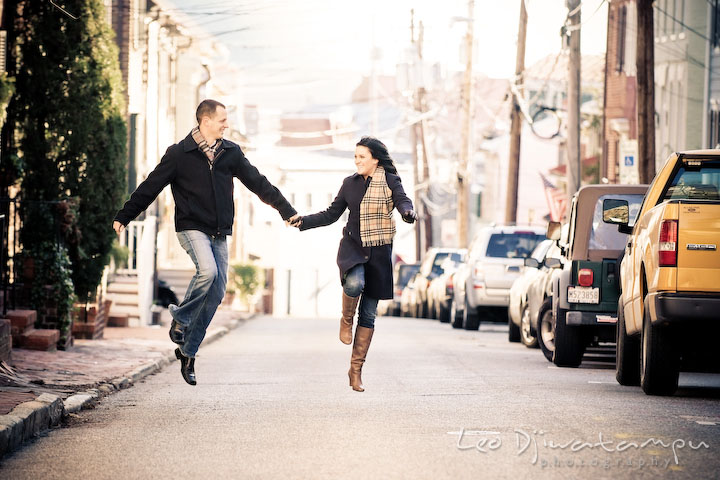 engaged couple jumping on narrow city street. Urban City Pre-wedding Engagement Photographer Annapolis MD