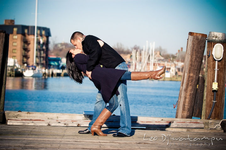 engaged couple kissing, doing the dip, on dock by water. Urban City Pre-wedding Engagement Photographer Annapolis Eastport MD