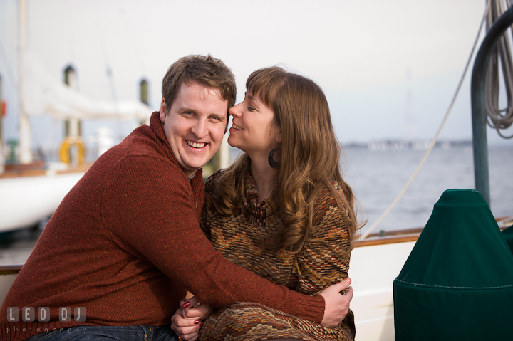 Engaged guy smiling hugging his fiancée. Pre-wedding engagement photo session at Annapolis, Eastport, Maryland, Quiet Waters Park, by wedding photographers of Leo Dj Photography. http://leodjphoto.com