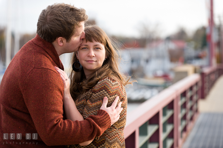 Engaged girl kissed by her fiancé on the bridge. Pre-wedding engagement photo session at Annapolis, Eastport, Maryland, Quiet Waters Park, by wedding photographers of Leo Dj Photography. http://leodjphoto.com