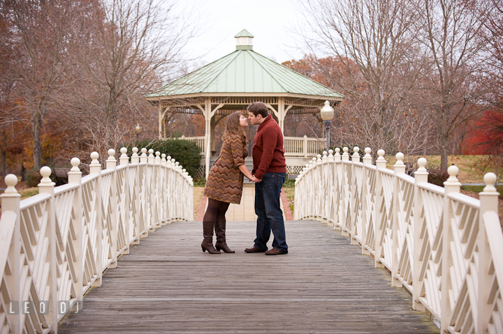 Engaged couple kissing on a bridge by a gazebo. Pre-wedding engagement photo session at Annapolis, Eastport, Maryland, Quiet Waters Park, by wedding photographers of Leo Dj Photography. http://leodjphoto.com