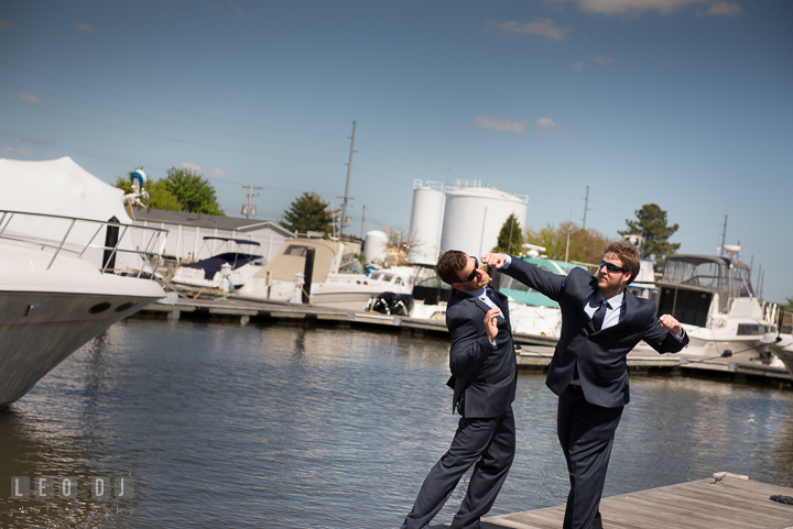 Groom and Best Man pretending to fight at Hilton Garden Inn boat dock. Kent Island Maryland Matapeake Beach wedding ceremony and getting ready photo, by wedding photographers of Leo Dj Photography. http://leodjphoto.com