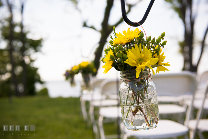 Yellow daisy flower on mason jar for decoration on isle for ceremony. Kent Island Maryland Matapeake Beach wedding ceremony and getting ready photo, by wedding photographers of Leo Dj Photography. http://leodjphoto.com