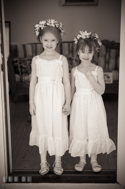 Two cute flower girls standing by a door holding hands. Kent Island Maryland Matapeake Beach wedding ceremony and getting ready photo, by wedding photographers of Leo Dj Photography. http://leodjphoto.com