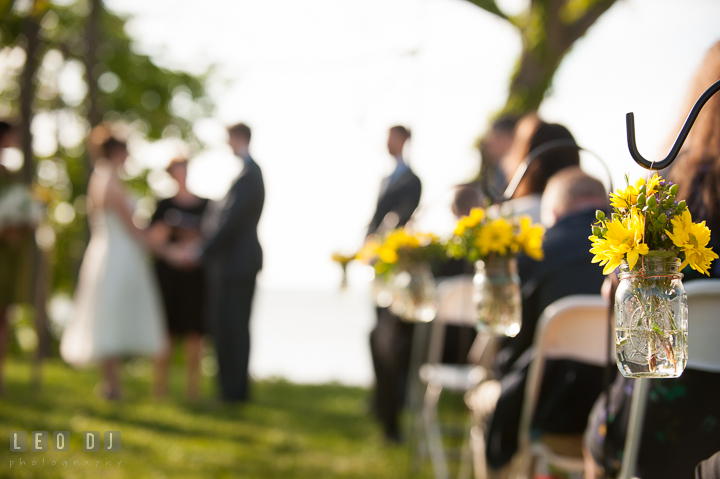 Flower decorations on the isle with Bride and Groom in the background. Kent Island Maryland Matapeake Beach wedding ceremony and getting ready photo, by wedding photographers of Leo Dj Photography. http://leodjphoto.com