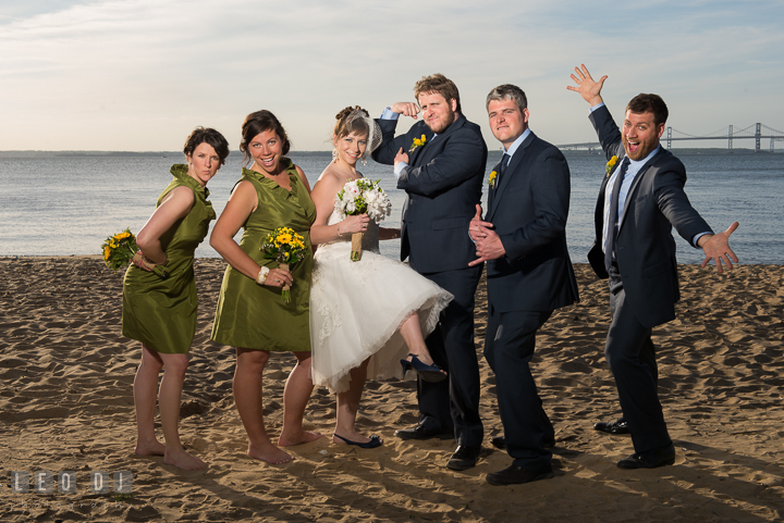 Wedding party of Bride, Groom, Bridesmaid, Maid of honor, Best Man and Groomsman goofy posing on the beach with Bay Bridge in the background. Kent Island Maryland Matapeake Beach wedding reception party and romantic session photo, by wedding photographers of Leo Dj Photography. http://leodjphoto.com