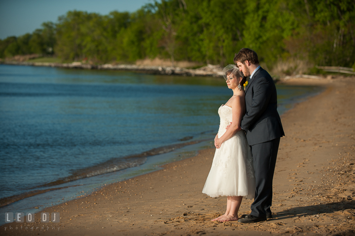 Groom hugging Bride on the beach. Kent Island Maryland Matapeake Beach wedding reception party and romantic session photo, by wedding photographers of Leo Dj Photography. http://leodjphoto.com