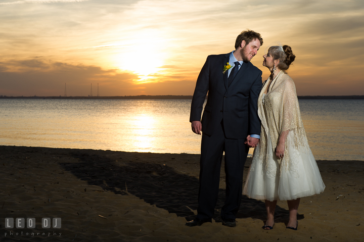 Bride and Groom on beach smiling at each other with sunset in the background. Kent Island Maryland Matapeake Beach wedding reception party and romantic session photo, by wedding photographers of Leo Dj Photography. http://leodjphoto.com