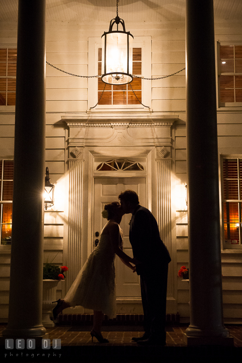 Silhouette of Bride and Groom kissing on the front porch of the building at the venue. Kent Island Maryland Matapeake Beach wedding reception party and romantic session photo, by wedding photographers of Leo Dj Photography. http://leodjphoto.com