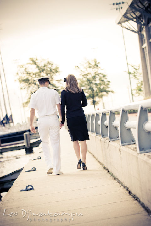 Engaged Navy gentleman walking with his fiancee. Pre-wedding engagement photo session USNA US Naval Academy with Navy boat, uniform, vintage clothing, and vintage car