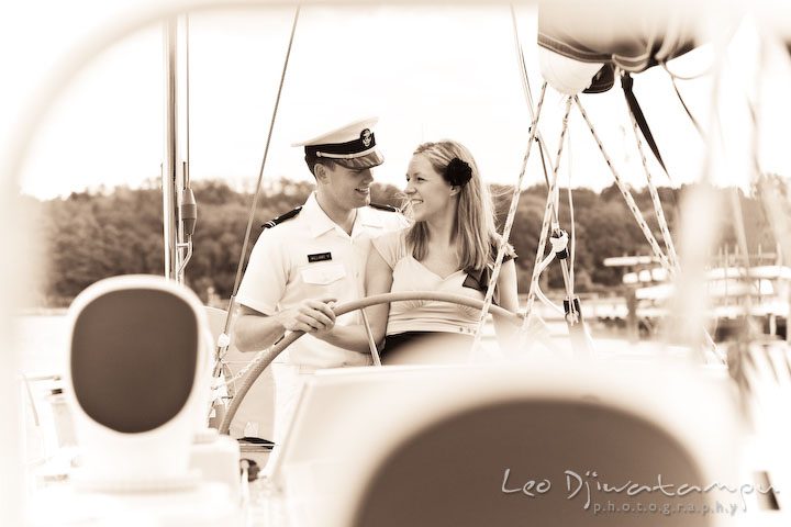 Vintage looking photo of Midshipman and his fiancee. Pre-wedding engagement photo session USNA US Naval Academy with Navy boat, uniform, vintage clothing, and vintage car