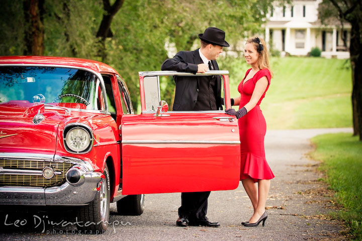 Engaged couple with an antique red car. Pre-wedding engagement photo session USNA US Naval Academy with Navy boat, uniform, vintage clothing, and vintage car