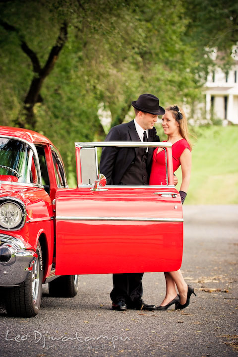 Engaged guy with hat hugging his fiancée. Pre-wedding engagement photo session USNA US Naval Academy with Navy boat, uniform, vintage clothing, and vintage car