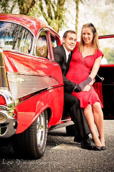 Engaged couple sitting on red antique car chair. Pre-wedding engagement photo session USNA US Naval Academy with Navy boat, uniform, vintage clothing, and vintage car