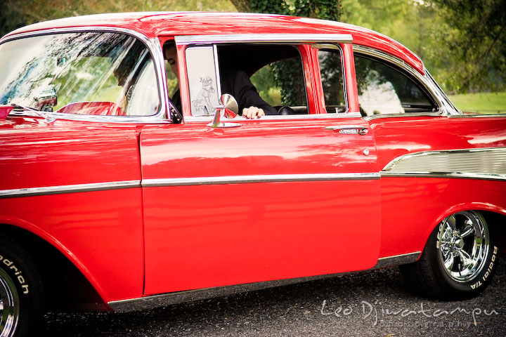 Engaged guy opened antique car door. Pre-wedding engagement photography session old antique Chevy Bel Air car, dress, outfit, accessories, suitcases