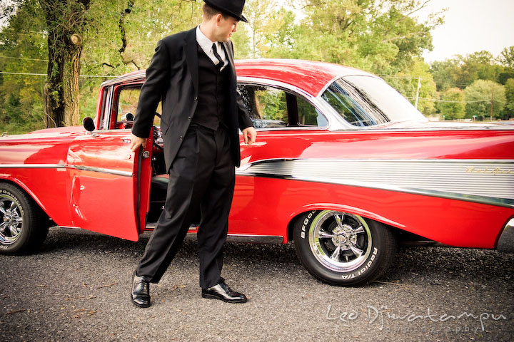 Engaged gentleman closing the vehicle door. Pre-wedding engagement photography session old antique Chevy Bel Air car, dress, outfit, accessories, suitcases