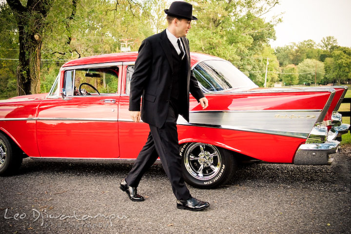 Engaged guy walking around his car. Pre-wedding engagement photography session old antique Chevy Bel Air car, dress, outfit, accessories, suitcases