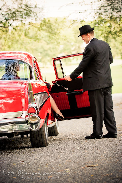 Engaged guy opened door, and his fiancee stepping out. Pre-wedding engagement photography session old antique Chevy Bel Air car, dress, outfit, accessories, suitcases