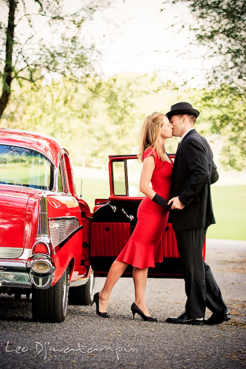 Engaged girl kissing her fiancee. Pre-wedding engagement photography session old antique Chevy Bel Air car, dress, outfit, accessories, suitcases