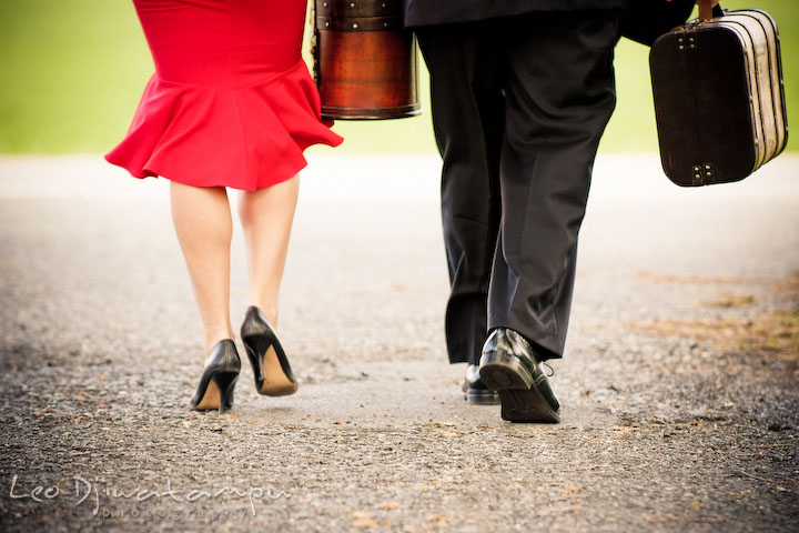 Engaged guy and girl walking on the street carrying suitcases. Pre-wedding engagement photography session old antique Chevy Bel Air car, dress, outfit, accessories, suitcases