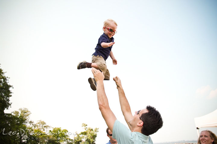 Father playing and throwing up his toddler son up in the air. Cove Creek Country Club, Stevensville, Kent Island, Eastern Shore, Maryland Wedding Photographer, beach wedding photographer