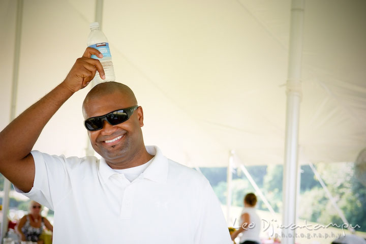 Guest putting cold water bottle on his head. Cove Creek Country Club, Stevensville, Kent Island, Eastern Shore, Maryland Wedding Photographer, beach wedding photographer