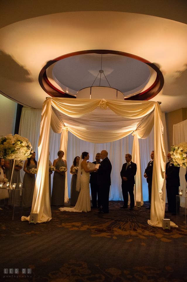 Westin Annapolis Hotel bride and groom reading vows during ceremony under canopy photo by Leo Dj Photography