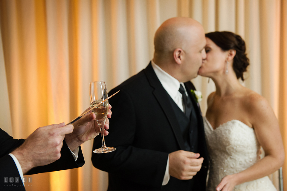 Westin Annapolis Hotel bride and groom kissing while guests clinking glasses photo by Leo Dj Photography