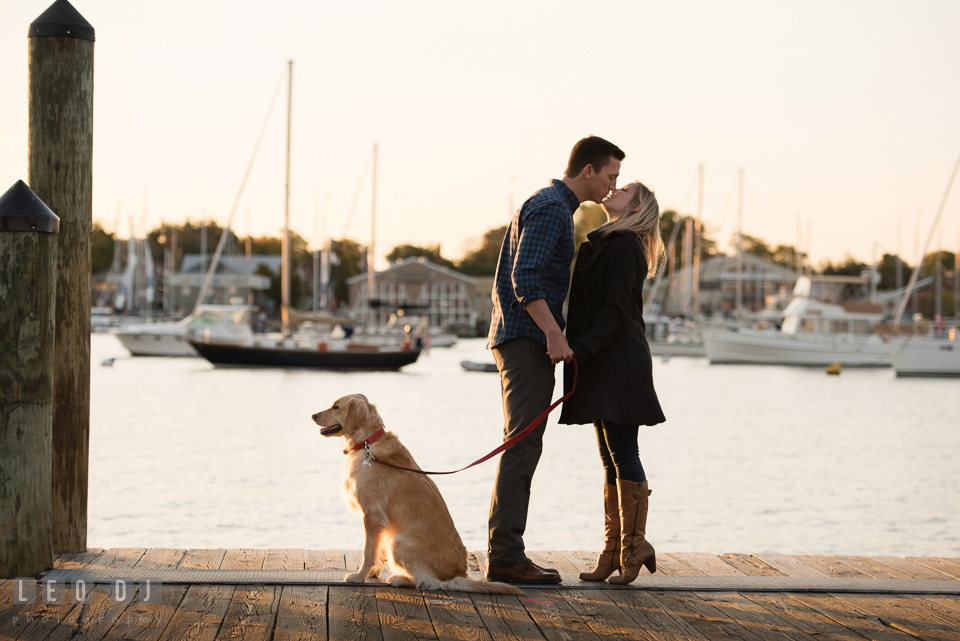 Downtown Annapolis Maryland engaged couple with their dog at dock almost kissing engagement photo by Leo Dj Photography.