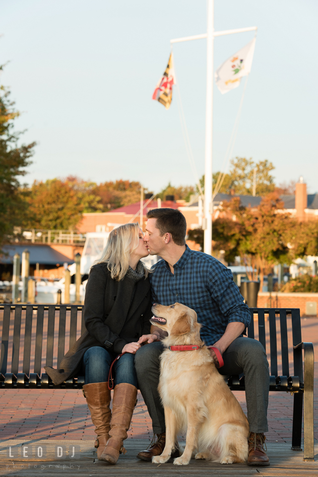 Downtown Annapolis Maryland man kissing his fiancée and dog looking photo by Leo Dj Photography.
