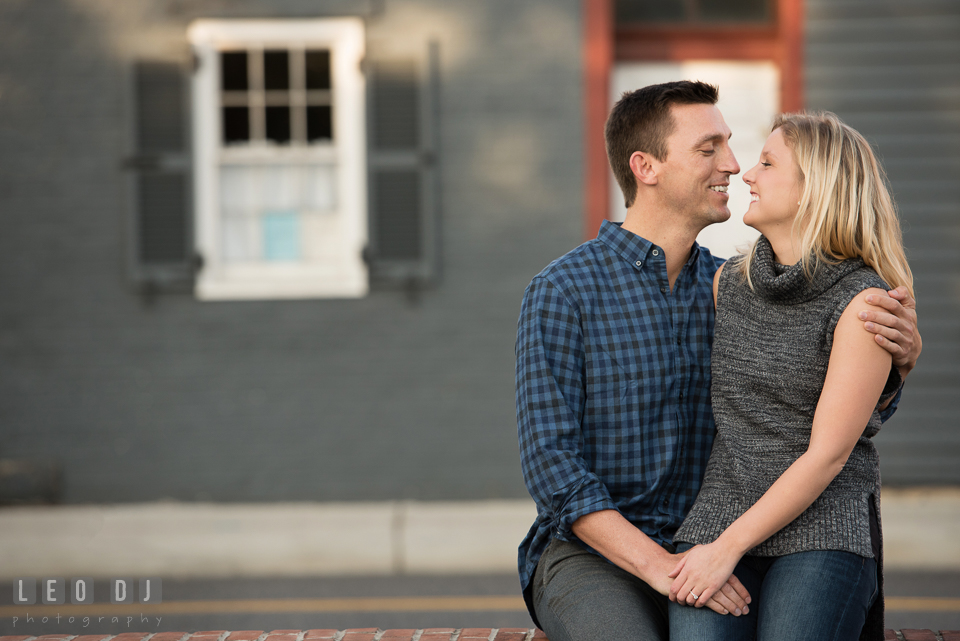 Downtown Annapolis Maryland engaged couple cuddling in front of the Summer Garden Theater photo by Leo Dj Photography.