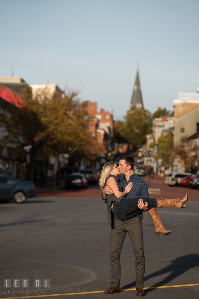 Downtown Annapolis Maryland engaged girl lifted up by her fiance and kissing photo by Leo Dj Photography.