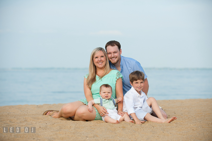 Family sitting and posing together on a beach. Chesapeake Bay, Kent Island, Annapolis, Eastern Shore Maryland children and family lifestyle portrait photo session by photographers of Leo Dj Photography. http://leodjphoto.com
