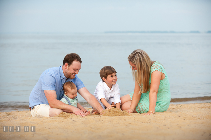 Happy family playing beach sand together. Chesapeake Bay, Kent Island, Annapolis, Eastern Shore Maryland children and family lifestyle portrait photo session by photographers of Leo Dj Photography. http://leodjphoto.com