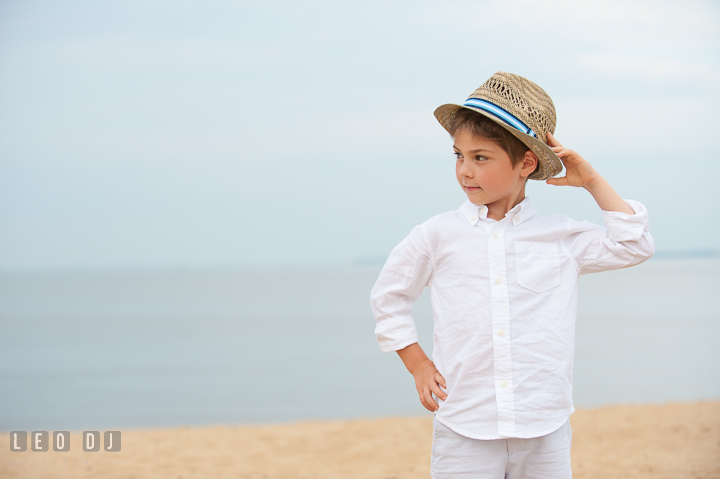 Young boy smiling and posing with his straw fedora hat. Chesapeake Bay, Kent Island, Annapolis, Eastern Shore Maryland children and family lifestyle portrait photo session by photographers of Leo Dj Photography. http://leodjphoto.com