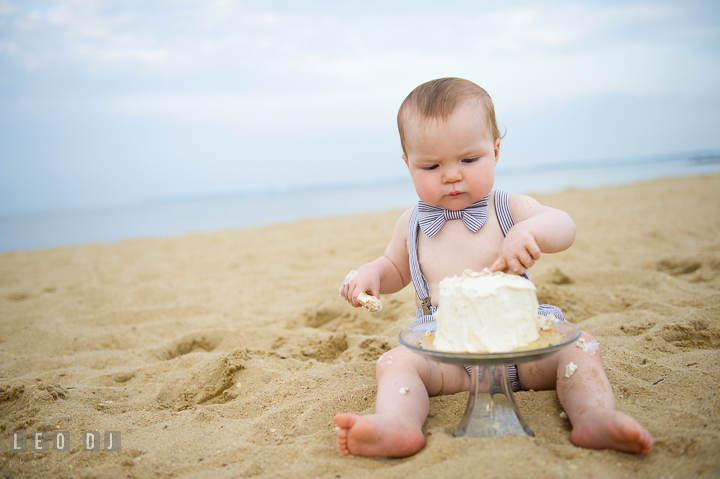 Little baby boy on beach playing with the icing on his birthday cake. Chesapeake Bay, Kent Island, Annapolis, Eastern Shore Maryland children and family lifestyle portrait photo session by photographers of Leo Dj Photography. http://leodjphoto.com