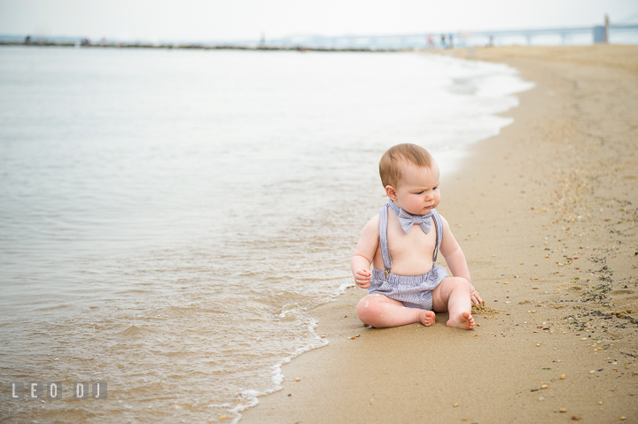 Cute baby boy sitting on the beach by the water. Chesapeake Bay, Kent Island, Annapolis, Eastern Shore Maryland children and family lifestyle portrait photo session by photographers of Leo Dj Photography. http://leodjphoto.com