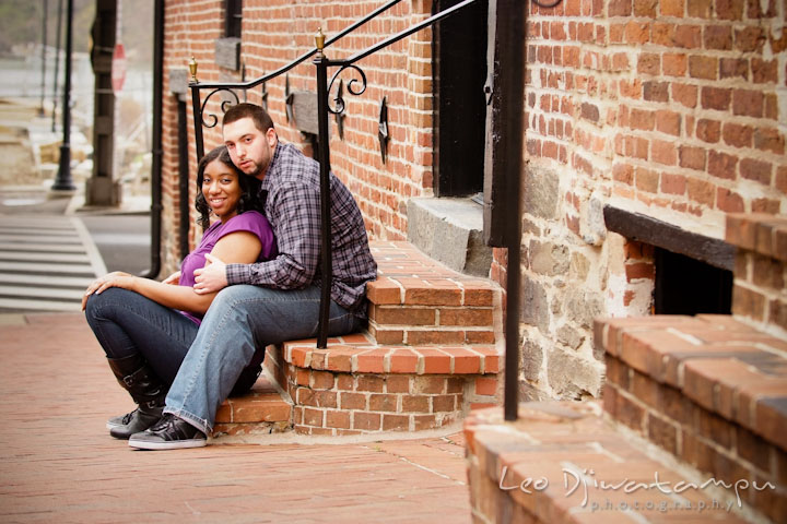 Engaged couple sitting on brick steps. Pre wedding engagement photo session at Georgetown, Washington DC by wedding photographer Leo Dj Photography