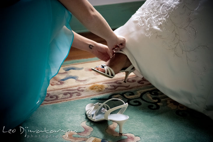 Matron of honor put on bride's shoes. Kitty Knight House Georgetown Maryland wedding photos by photographers of Leo Dj Photography.