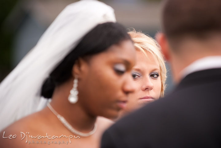 Maid of honor looking at bride during ceremony. Kitty Knight House Georgetown Maryland wedding photos by photographers of Leo Dj Photography.