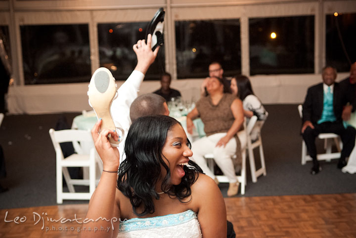 Bride holding up her shoes during shoe game. Kitty Knight House Georgetown Maryland wedding photos by photographers of Leo Dj Photography.